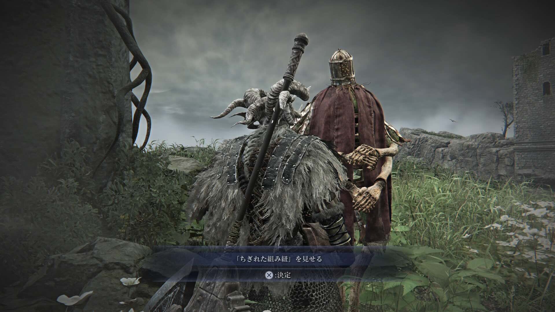 ちぎれた組み紐を石碑前の召使人形に見せる